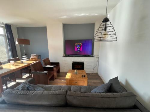 a living room with a couch and a tv on a wall at Topsleep Apartments 24-2 in Arnhem