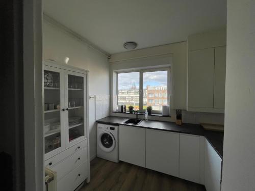 een keuken met een wastafel en een wasmachine bij Appartement Arnhem in Arnhem