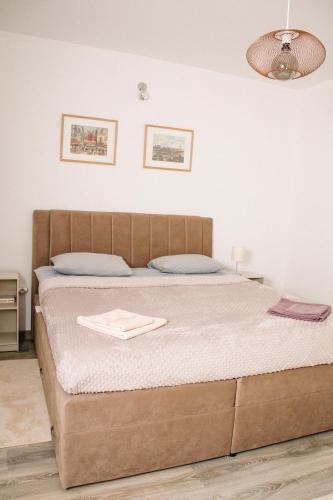 a bedroom with a large bed with a brown headboard at Apartman Stella in Bosanska Gradiška