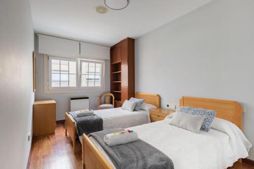 a bedroom with two beds and a window at PISO MODERNO COMPLETO LOVE MARIN 2 in Marín