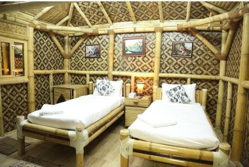 a bedroom with two beds in a wooden room at Shorfet Al Alamin Hotel in Al Ḩamrāʼ