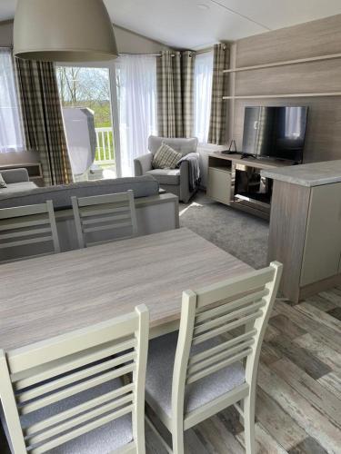 a living room with a wooden table and chairs at Luxury Holiday Home Sleeps 6 in St Austell