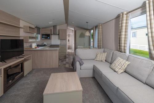 ein Wohnzimmer mit Couch und Küche in der Unterkunft Luxury Holiday Home Sleeps 6 Pet Friendly in St Austell