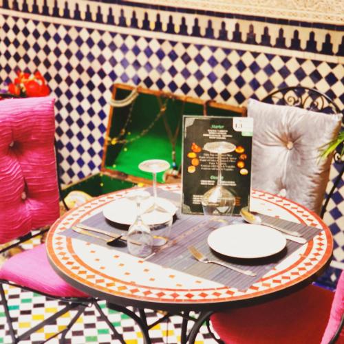 a table with plates and a box on it at Riad Dar Kassim in Fès