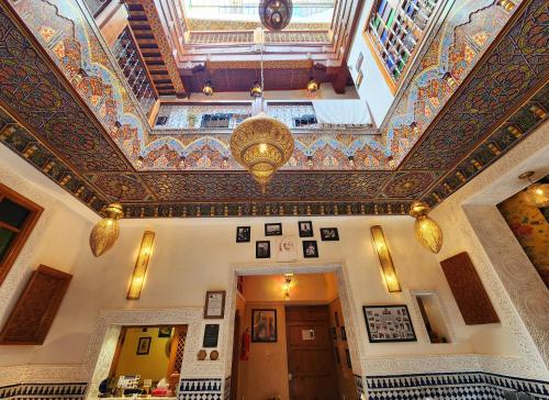 un soffitto decorato in un edificio con lampadario pendente di Riad Dar Kassim a Fes