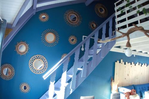 a blue room with stairs and mirrors on the wall at Le Blue CoCo - 1 minute de la plage in Sainte-Anne