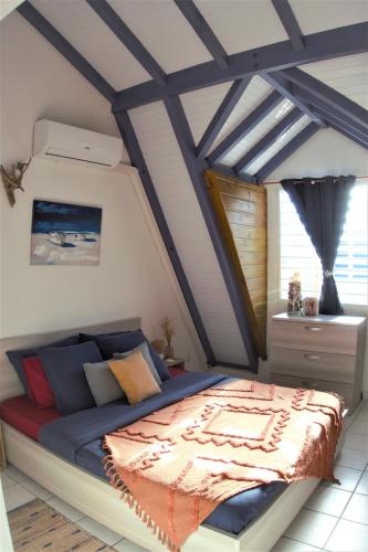 a bedroom with a bed in a room at Le Blue CoCo - 1 minute de la plage in Sainte-Anne