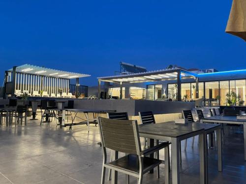 un restaurant avec des tables et des chaises sur le toit dans l'établissement Mass Paradise Hotel, à Aqaba
