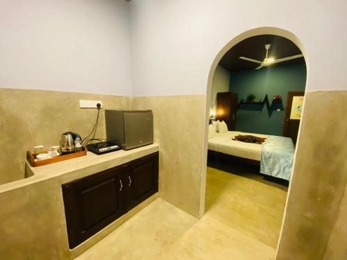 a room with a bedroom with a bed and a mirror at Nilaveli Hybrid Holiday Hotel in Nilaveli
