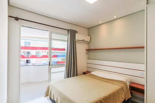 1 dormitorio con cama y ventana grande en Maravilhosa vista para o mar - HB16F, en Florianópolis