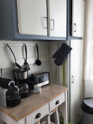 une cuisine avec un comptoir avec un micro-ondes et une cuisinière dans l'établissement Avec un minimum de 3 nuits Studio 80 m de la mer et 300 m des commerces, au Tréport