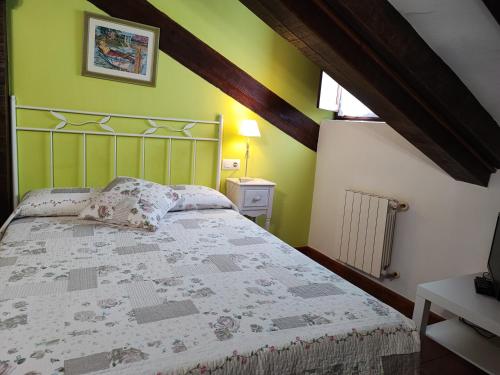a bedroom with a bed in a room with green walls at Pasaje San Jorge in Comillas