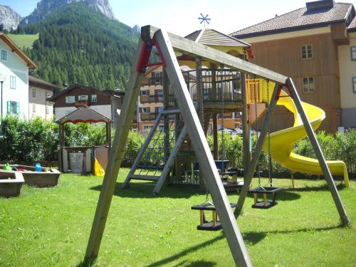 un parque infantil con un tobogán en el césped en Casa Fior del Soreie, en Pozza di Fassa