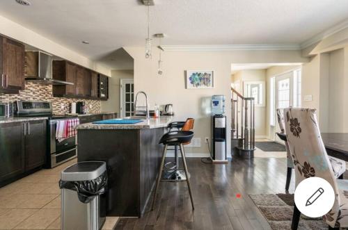 a kitchen with a counter and some chairs in it at Mannys place in Nepean