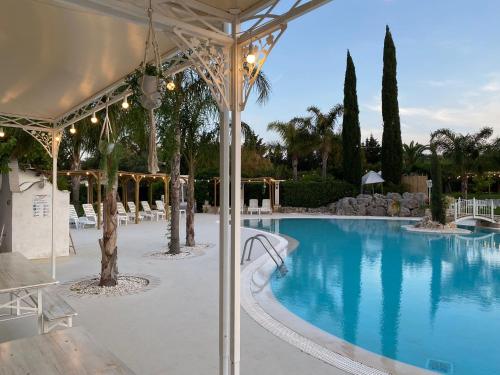 a swimming pool with a pavilion next to a resort at All`Ombra del Carrubo in Polignano a Mare