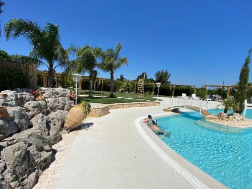 a man in a swimming pool in a resort at All`Ombra del Carrubo in Polignano a Mare