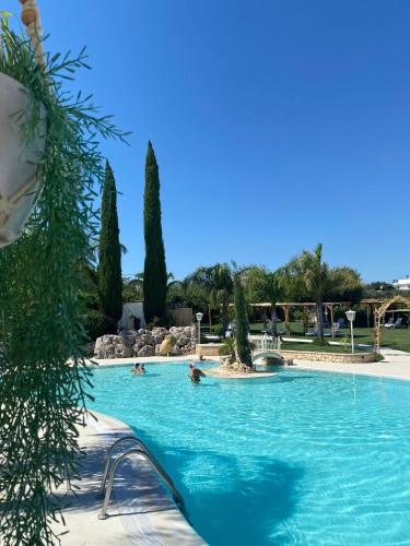 a swimming pool with people in the water at All`Ombra del Carrubo in Polignano a Mare
