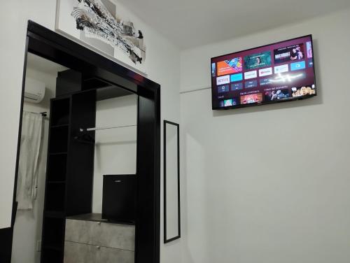 TV de pantalla plana en la pared de una habitación en Vilapicina Hostal, en Barcelona