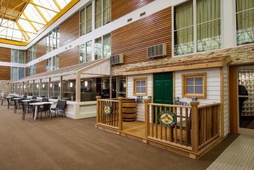 a building with a green door and tables and chairs at Superior Inn Hotel and Conference Centre Thunder Bay in Thunder Bay