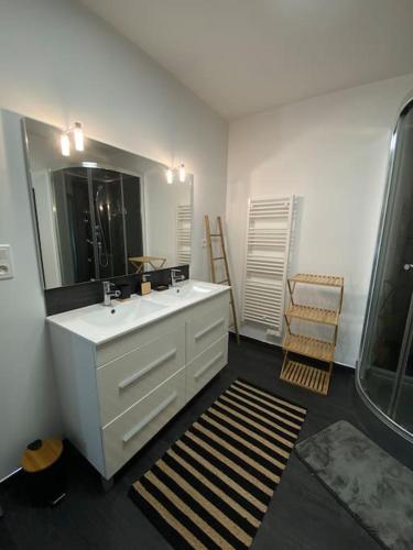 une salle de bain avec un lavabo blanc et un miroir dans l'établissement Gite comme chez soi Ducey les Chèris, à Ducey