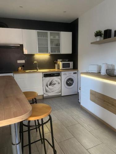 une cuisine avec un lave-linge et un lave-linge dans l'établissement Gite comme chez soi Ducey les Chèris, à Ducey