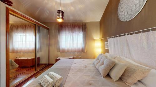 een slaapkamer met een groot bed en een grote spiegel bij Estudio en la playa con spa opcional in Gran Alacant