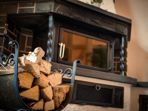 a basket of fire wood in front of a fireplace at Schneiderlein Hotel in Limbach - Oberfrohna