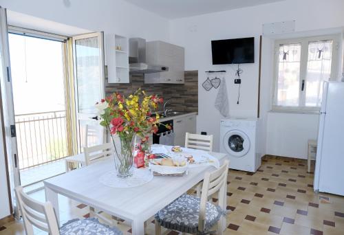 eine Küche mit einem Tisch und einer Blumenvase darauf in der Unterkunft Casa Santa Rita / Locazione turistica Sicilia / Santa Domenica Vittoria in Santa Domenica Vittoria