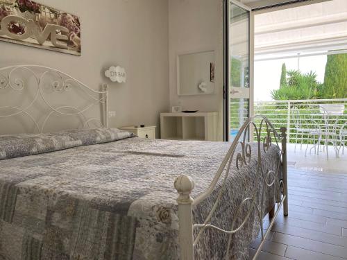 a bedroom with a bed and a large sliding glass door at All`Ombra del Carrubo in Polignano a Mare
