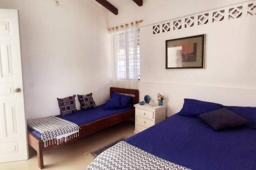 1 dormitorio con 2 camas y sábanas azules en Casa Albatros (Playa-Esmeraldas) en Tonsupa