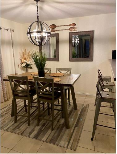 a dining room table with chairs and a chandelier at Cozy5star in Killeen