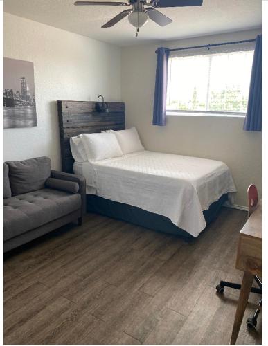 1 dormitorio con cama, sofá y ventana en Cozy5star, en Killeen