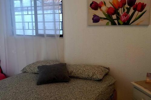 a bedroom with a bed with a pillow and a window at Casa Albatros (Playa-Esmeraldas) in Tonsupa