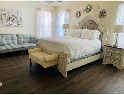 ein Schlafzimmer mit einem Bett, einem Stuhl und einem Sofa in der Unterkunft Cozy5star in Killeen