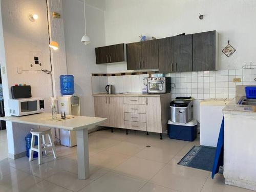 a kitchen with wooden cabinets and a table in it at Casa Albatros (Playa-Esmeraldas) in Tonsupa