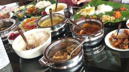 a table with many different dishes of food on it at Grand Villa Houseboat in Kumarakom