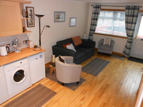 uma sala de estar com um sofá e uma cadeira em Orkneyinga em Kirkwall