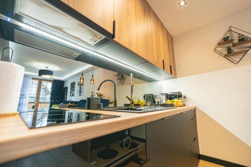 een keuken met houten kasten en een aanrechtblad bij Apartament Blue Diamond in Karpacz