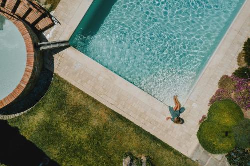 una vista aérea de una piscina con un hombre de pie junto a ella en Poggio Martino, en Cignano