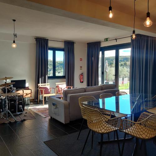 a living room with a couch and a table and chairs at Eira da Fraga in Vila Nova de Foz Coa