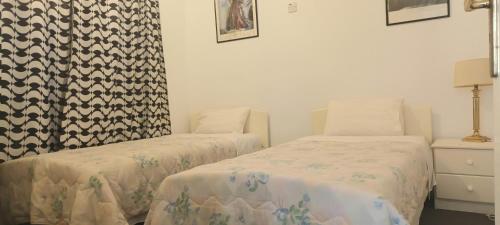 a bedroom with two beds and a dresser at Greenfields Country Club in Limassol