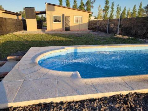 una piscina en un patio con una casa en Cabañas Iñ Püñen, en General Belgrano