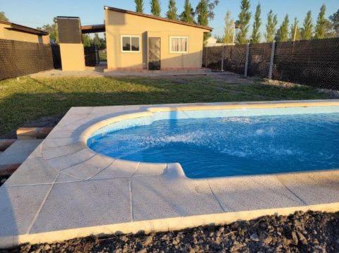 una piscina en un patio con una casa en Cabañas Iñ Püñen en 