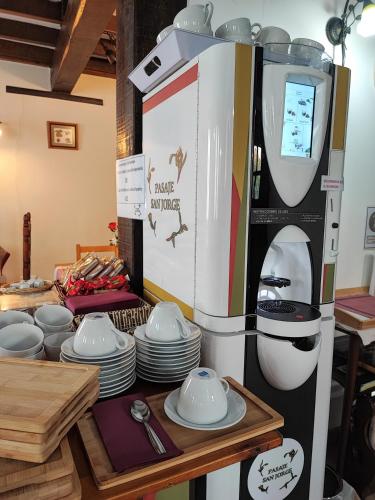 a coffee machine next to a table with plates at Pasaje San Jorge in Comillas