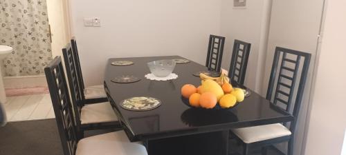 a black table with a bowl of fruit on it at Greenfields Country Club in Limassol