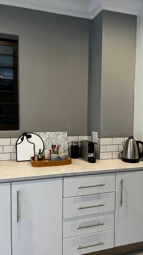 a kitchen with white cabinets and a counter top at Robyns Nest Self Catering Cottage No1 in Kloof