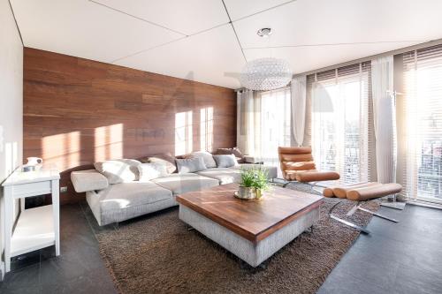 ein Wohnzimmer mit einem Sofa und einem Tisch in der Unterkunft Apartament Nadbrzeżna de luxe in Mielno