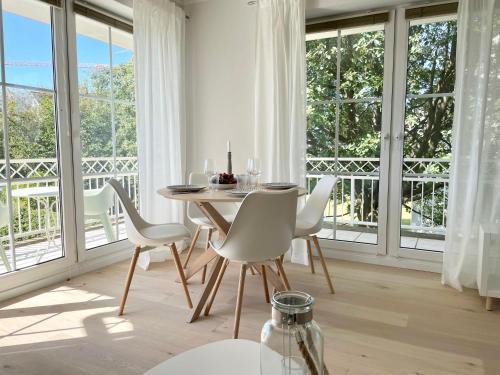 ein Esszimmer mit einem Tisch, Stühlen und Fenstern in der Unterkunft Turmresidenz 6 KaMare - 300m zum Strand in Scharbeutz