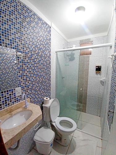 een badkamer met een toilet, een wastafel en een douche bij HOTEL PINHEIRO CENTER in Pinheiro
