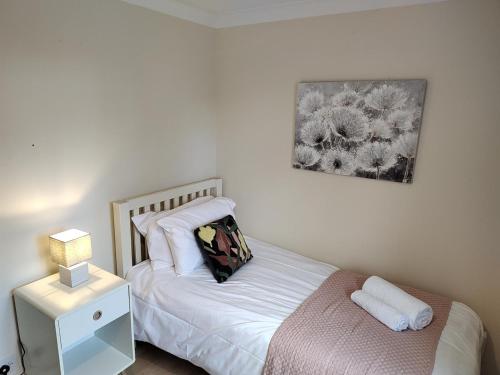 a bedroom with a bed and a night stand with a lamp at Wentworth Drive Contractor and family 3 bed Home Grantham in Lincolnshire